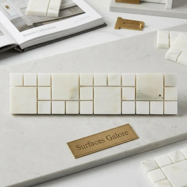 White marble mosaic tile strip with subtle veining in varying square sizes calacatta verde royale 3x12 rimini border polished or honed