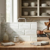 White marble-effect subway tile backsplash featuring calacatta verde royale marble 4x12 deep-beveled polished-honed design