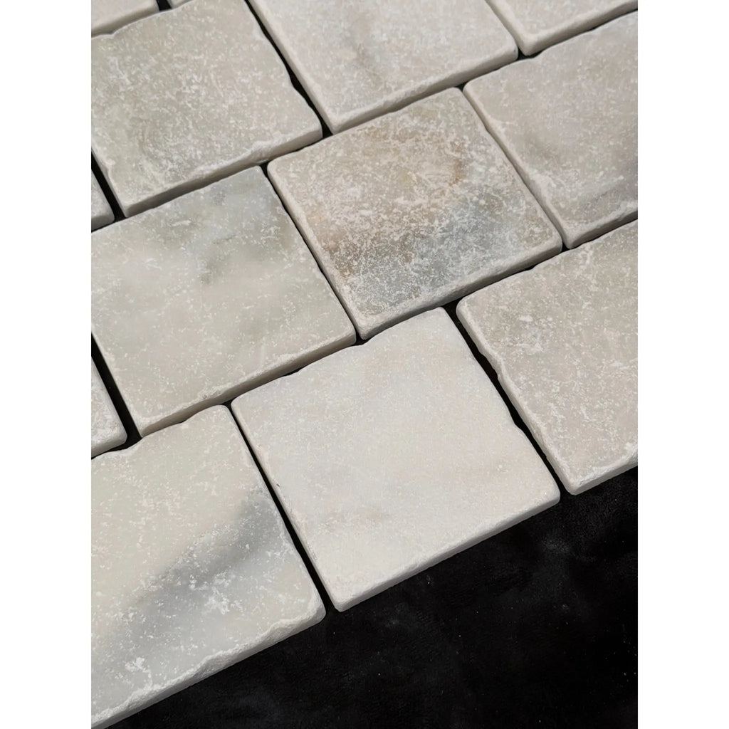 Calacatta verde royale marble 4x4 tile tumbled in light gray with natural texture and subtle veining on square stone tiles