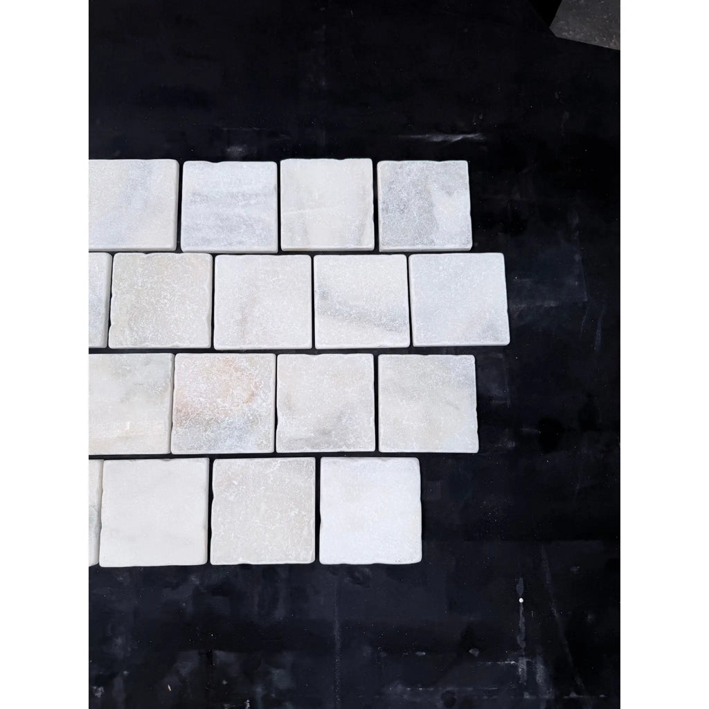 Calacatta verde royale marble 4x4 tumbled tile featuring white marble squares with subtle gray veining in staggered pattern