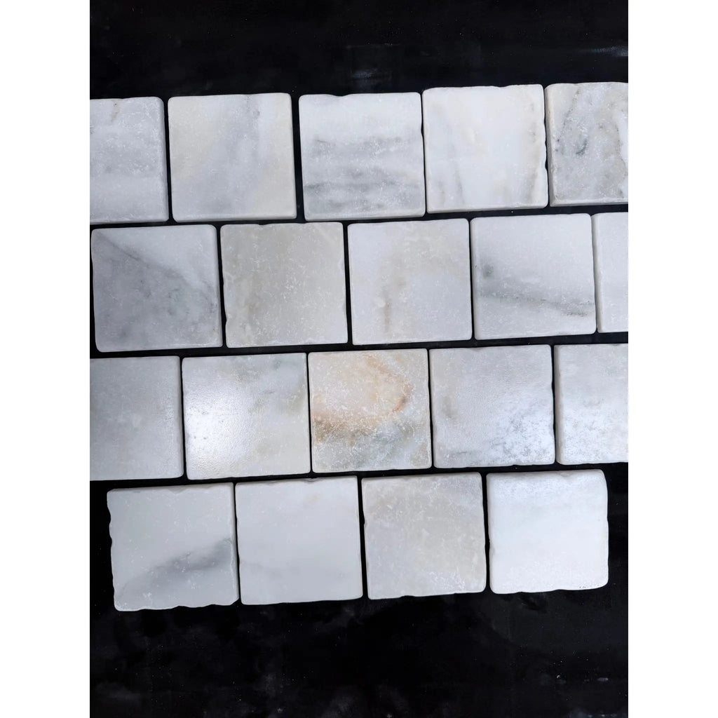 Calacatta verde royale marble 4x4 tile tumbled white marble with subtle gray veining arranged in a grid pattern