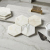 White hexagonal calacatta verde royale marble coasters with subtle gray veining polished or honed finish