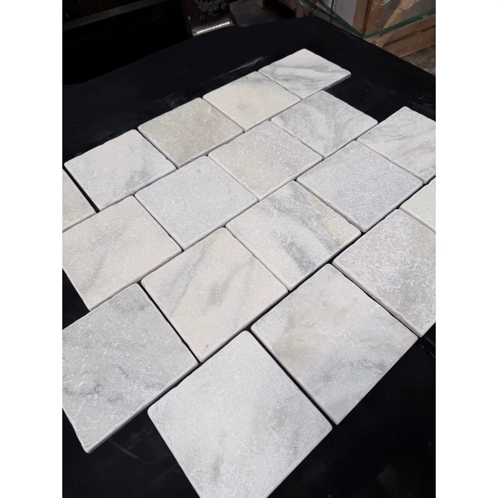 Calacatta verde royale marble 6x6 tile tumbled white marble with subtle gray veining in a herringbone pattern