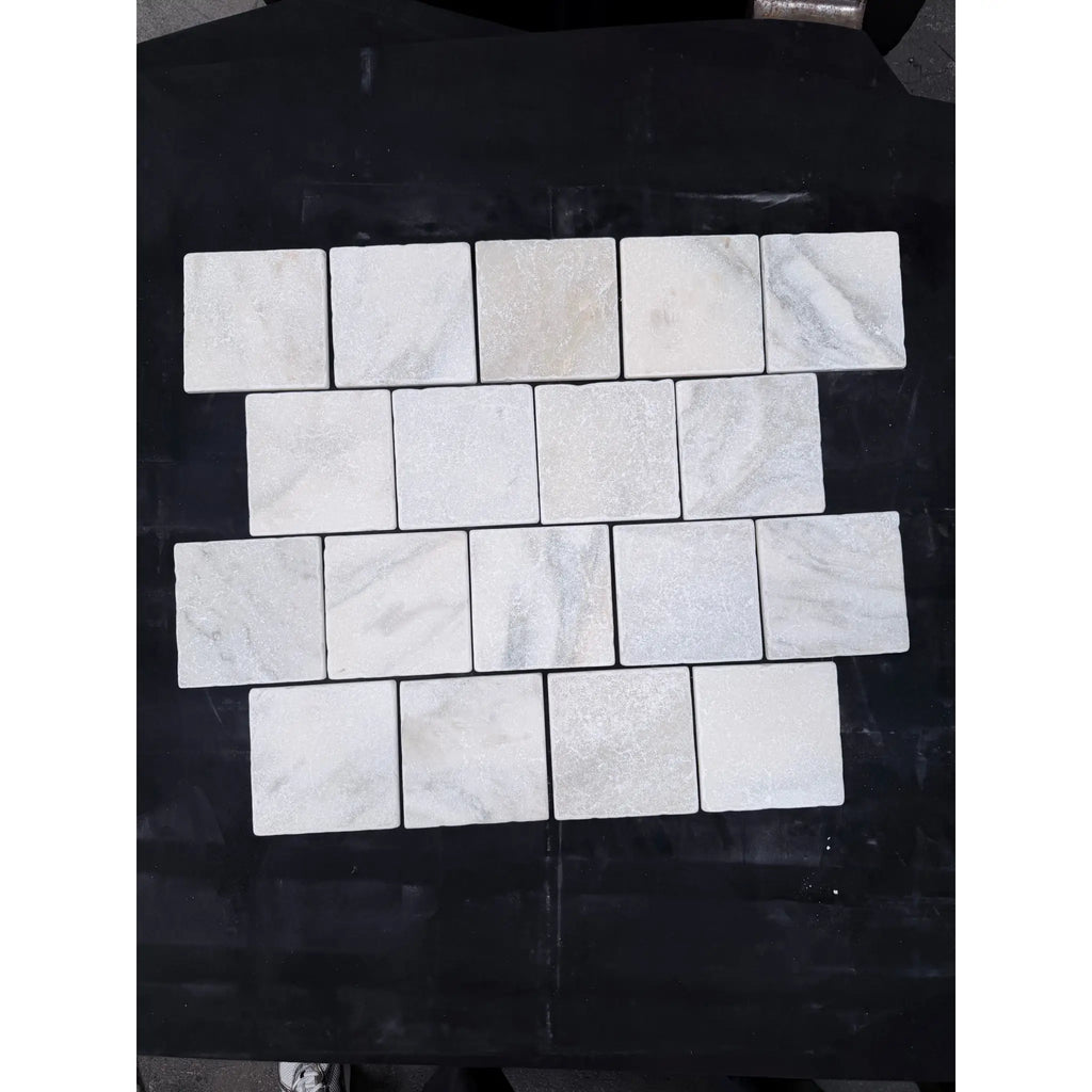White marble Calacatta Verde Royale 6x6 tumbled tile with subtle gray veining arranged in a staggered pattern