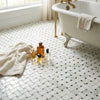 White marble mosaic tile floor with a herringbone pattern and black accent tiles in polished Calacatta Verde Royale