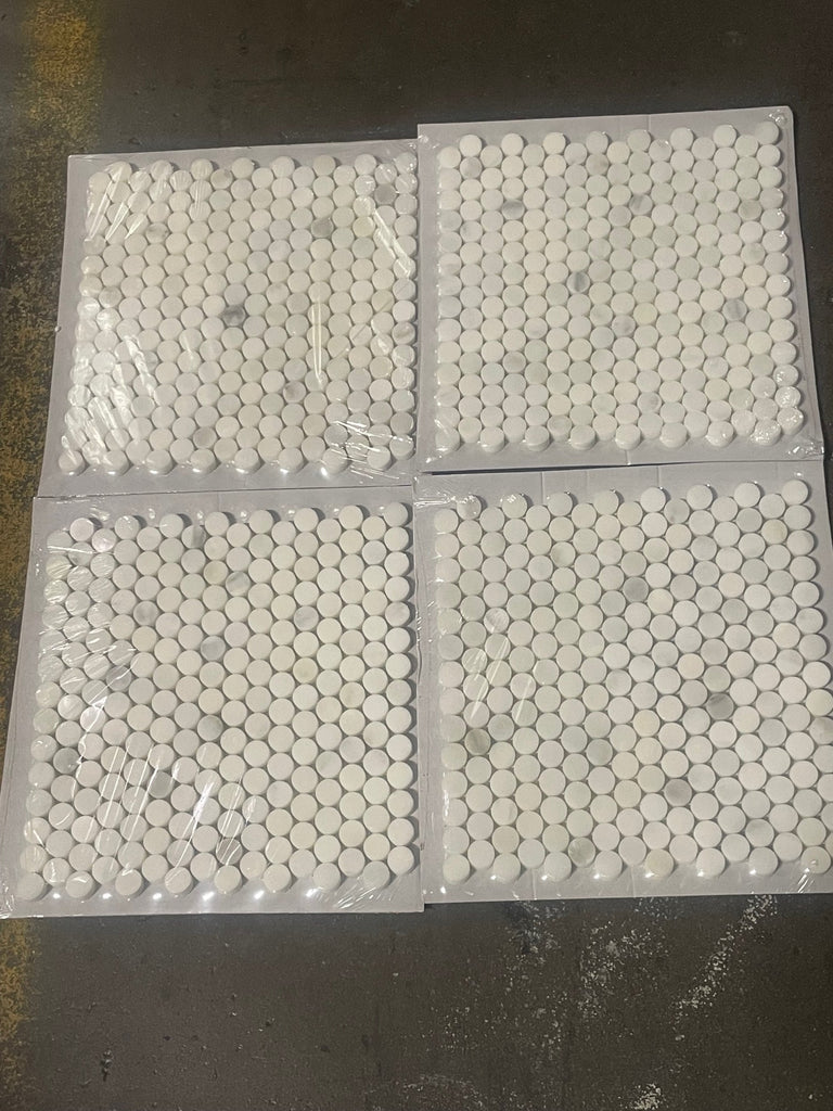 Four sheets of white penny round mosaic tiles wrapped in plastic for Calacatta Oliva Marble