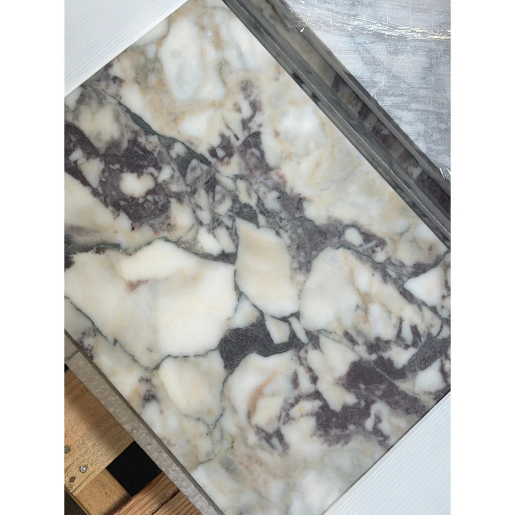 A polished Calacatta Viola Imperiale marble slab with creamy white, dark gray, and beige veins in 12x24 size