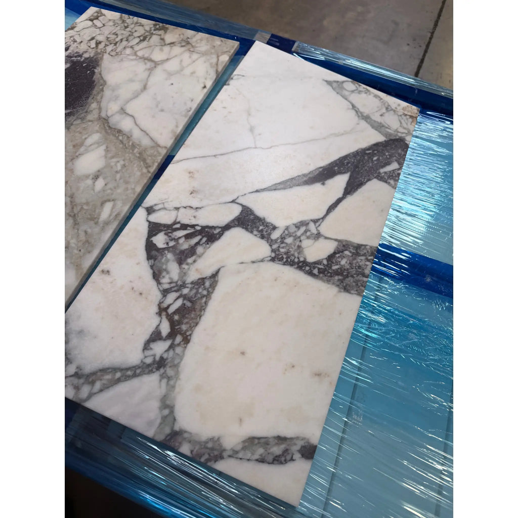 Calacatta Viola Imperiale marble slab, white with black gray veining, wrapped in plastic