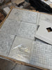 Carrara White 1x1 polished mosaic marble tiles in grid pattern on wood
