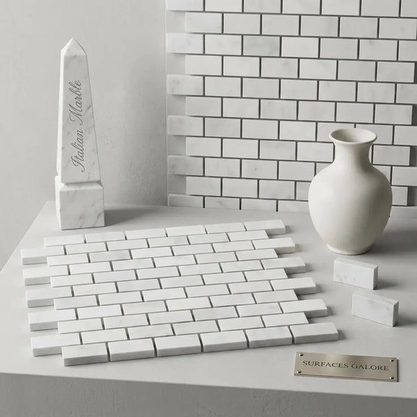 White indian marble obelisk with engraved text displayed alongside carrara white 1x2 brick mosaic marble tile polished or honed