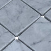 Diamond-shaped white marble mosaic tiles with gray veining in Carrara White 3X3 Tumbled design