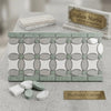 A decorative carrara white marble mosaic tile panel with oval and circular mirror pieces in ming green dots pattern