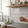Carrara white 5/8x5/8 polished marble mosaic tile backsplash with white tiles and a single red accent line