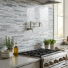Stainless steel kitchen faucet with sleek modern design and adjustable spray head beside carrara white bamboo sticks mosaic panel