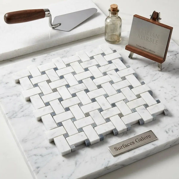 Carrara white basketweave mosaic marble tile in white and gray with blue-gray accents displayed on matching marble surface
