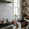 Copper farmhouse sink with rustic matte finish and integrated copper faucet paired with carrara white chevron marble tile