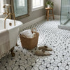 Wicker basket with handles holding white towels and bottle on polished carrara white florida flower mosaic marble tile
