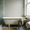 White clawfoot bathtub with subtle wear and vintage design next to polished Carrara white florida flower mosaic marble tile