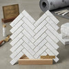 Carrara white herringbone mosaic 1x4 brick polished marble tile displayed on wooden stand