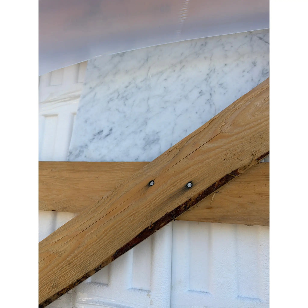 Intersecting light brown and dark wooden beams in Carrara White Marble design