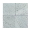 Four Carrara White Marble 12x12 Tumbled tiles displaying elegant veining and finish