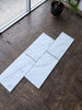 Carrara White Marble 12x24 tiles on brown textured surface