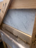 Carrara white marble 12x24 slab with gray veining in rustic wood frame