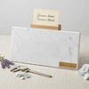 A sleek white carrara marble business card holder with gray veining and a wooden accent in polished 12x24 design