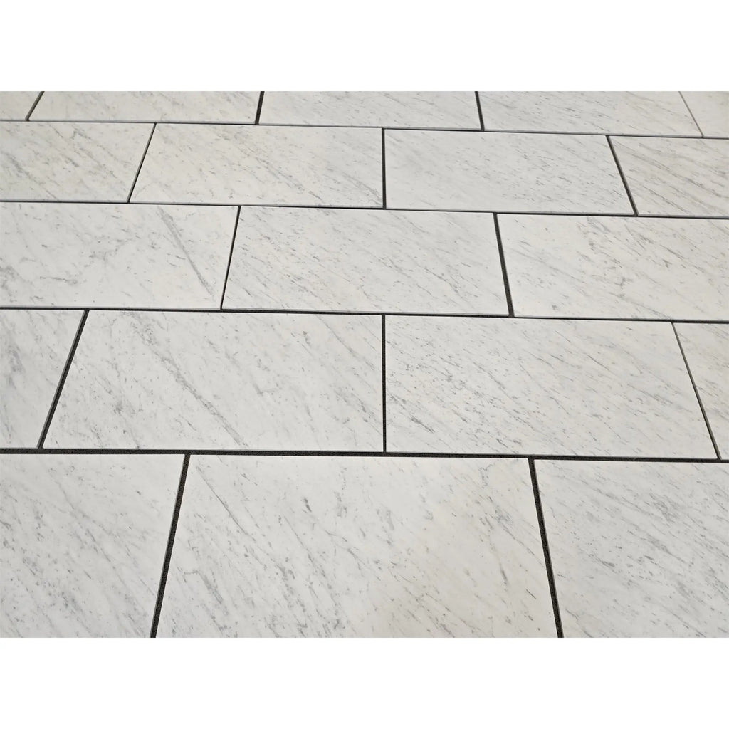 Carrara white marble 18x36 polished or honed rectangular floor tiles with subtle gray veining and dark grout lines