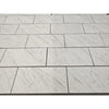 Carrara white marble 18x36 polished tiles with subtle gray veining arranged in a staggered pattern