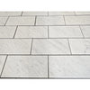 Carrara white marble 18x36 polished or honed tiles with subtle gray veining arranged in a staggered pattern