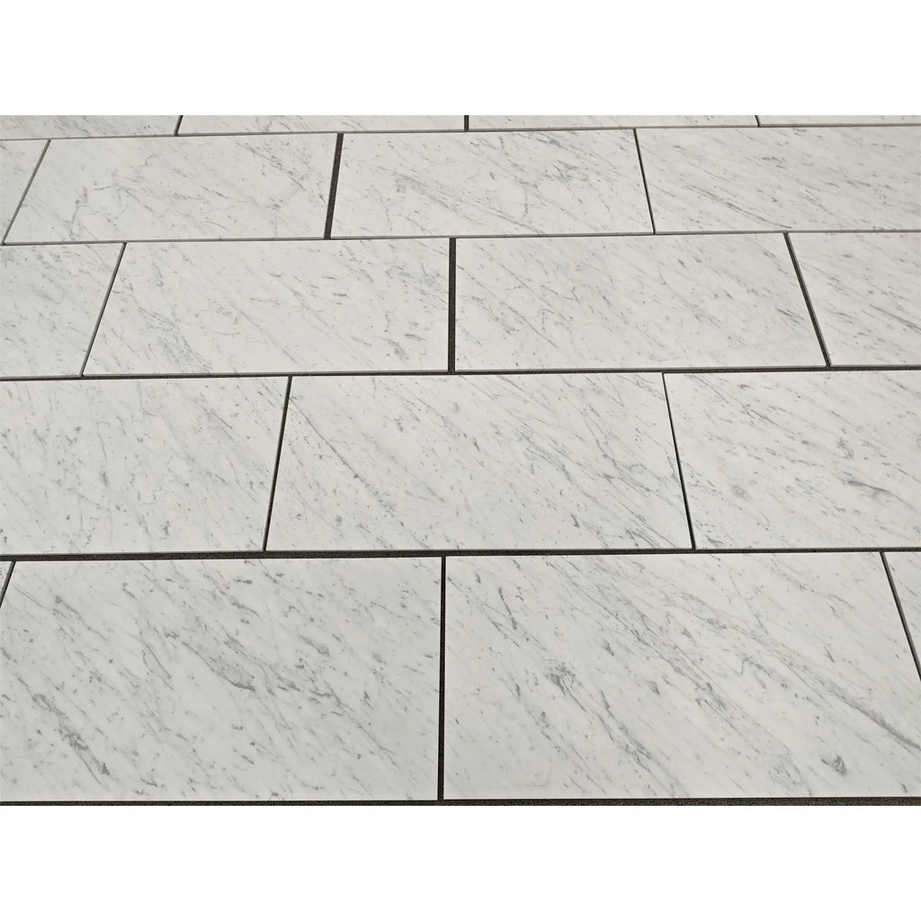 Carrara white marble 18x36 polished or honed tiles with subtle gray veining arranged in a staggered pattern