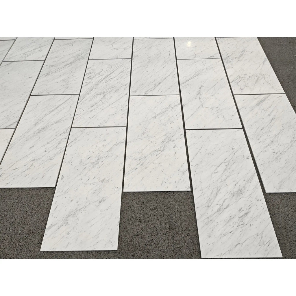 Carrara white marble 18x36 polished or honed tiles with subtle gray veining arranged in a staggered pattern