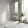 Gold-framed glass shower enclosure with sleek modern design and carrara white marble 2x8 polished or honed tiles