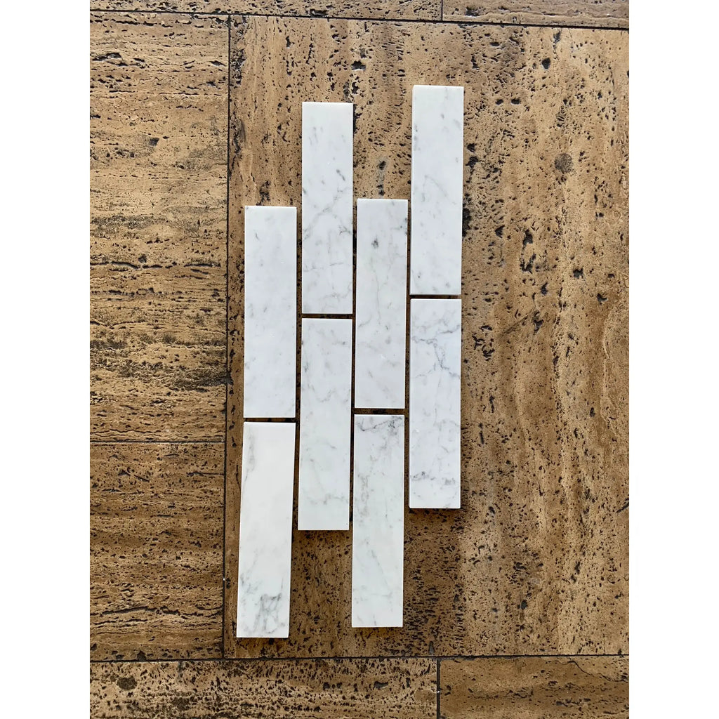 Carrara white marble 2x8 polished or honed subway tiles in white with subtle gray veining arranged in a staggered pattern