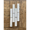 Carrara white marble 2x8 polished or honed subway tiles with subtle gray veining arranged in a vertical pattern