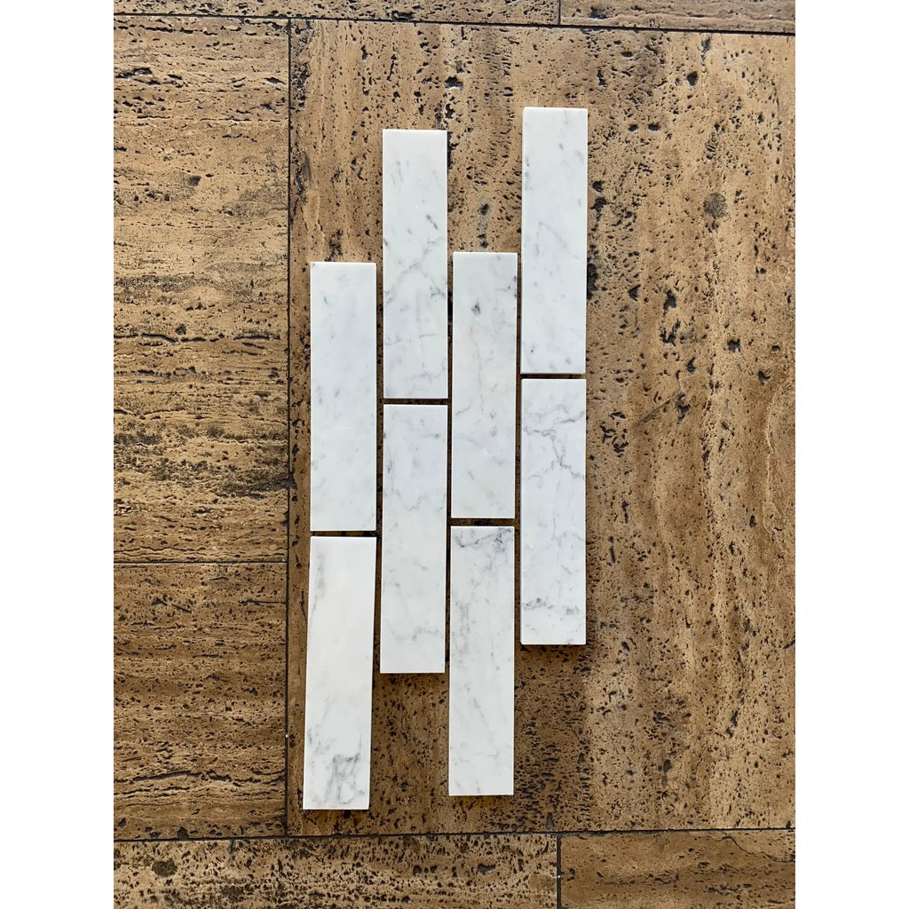 Carrara white marble 2x8 polished or honed subway tiles with subtle gray veining arranged in a vertical pattern