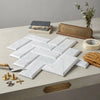 Carrara white marble 3x6 deep-beveled polished-honed tiles with subtle gray veining arranged in a herringbone pattern