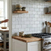 Carrara white marble 3x6 tumbled subway tile backsplash with subtle gray veining in white marble material