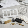 Carrara white marble 4 gang rocker switch wall plate with black toggle switches and gold screws