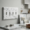 Carrara white marble 4 gang toggle switch wall plate with gray veining and four toggle switches in marble material