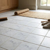 Carrara white marble 4x4 tumbled floor tiles with a white marble effect and subtle gray veining