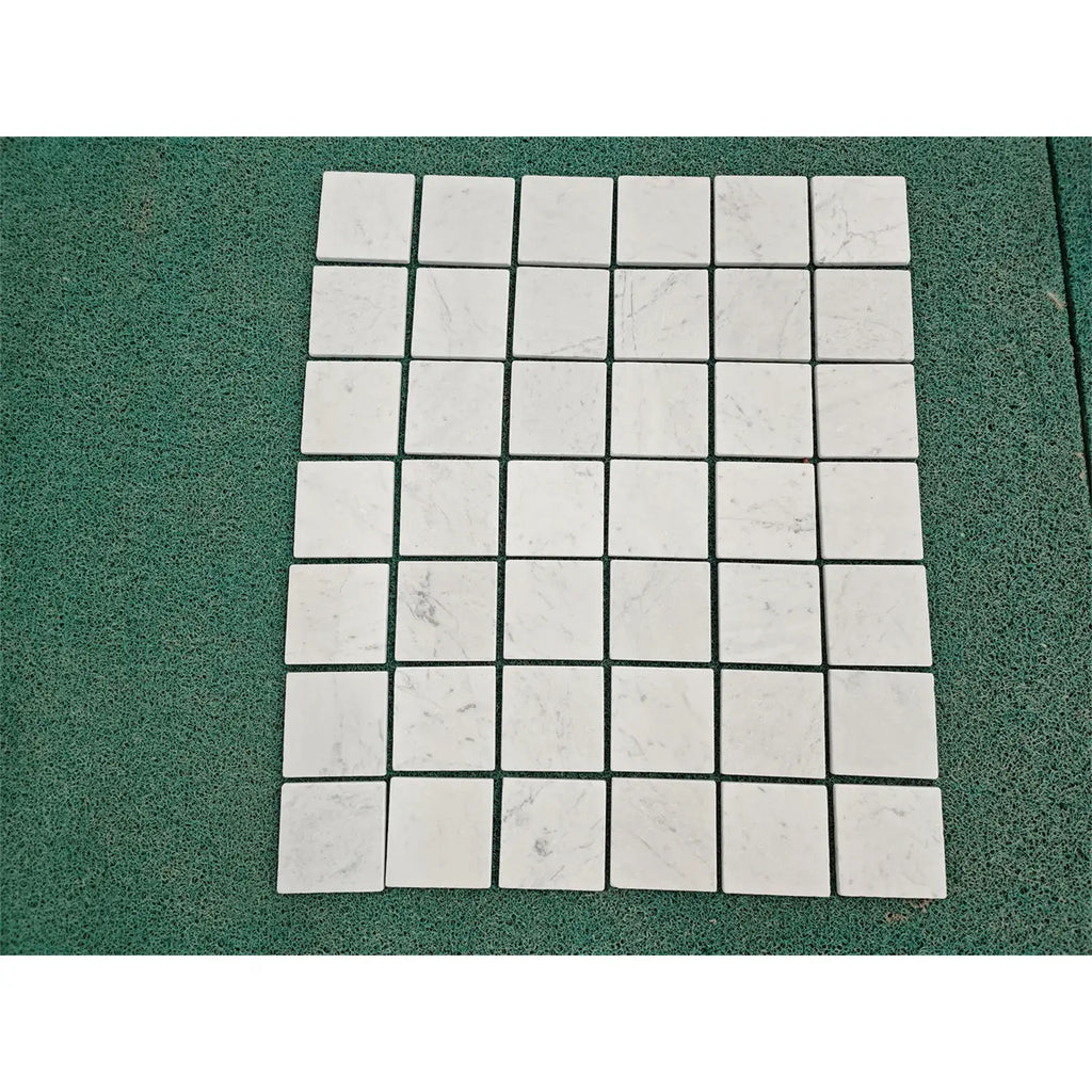 White marble mosaic tiles with subtle gray veining in a neat grid pattern carrara white marble 4x4 tumbled