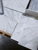 Carrara white marble 6x12 polished tiles with gray veining, stacked in plastic