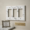 Carrara white marble triple rocker switch plate with elegant gray veining and three rectangular cutouts