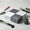 Stack of square coasters with white and dark gray checkered bardiglio imperiale and bianco dolomite marble pattern