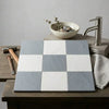 Square tiles with checkerboard pattern of bardiglio imperiale and oriental white marble finishes on wooden surface