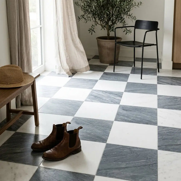 Brown leather chelsea boots resting on checkered bardiglio imperiale and thassos 18x18 white and gray marble floor tiles