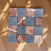 Checkerboard pattern of reddish-brown and dark gray marble tiles with white veining