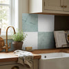 The checkerboard bianco dolomite and ming green 12x12 kitchen backsplash features alternating teal and white marble-like tiles